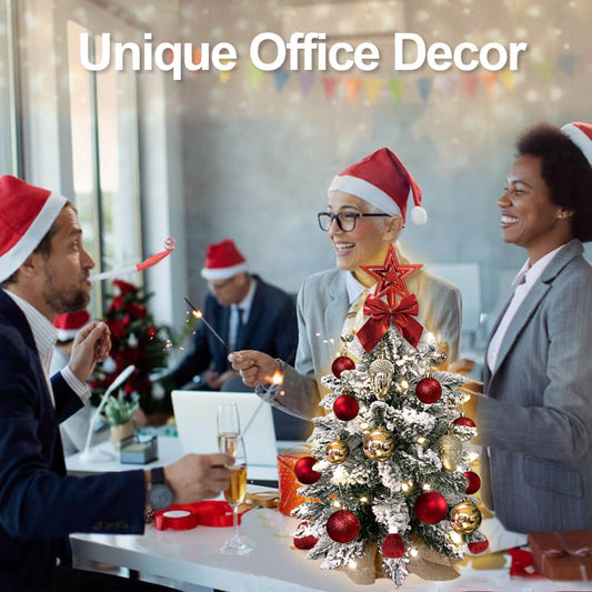 People in an office setting with Christmas decor, including a small tree and Santa hats.