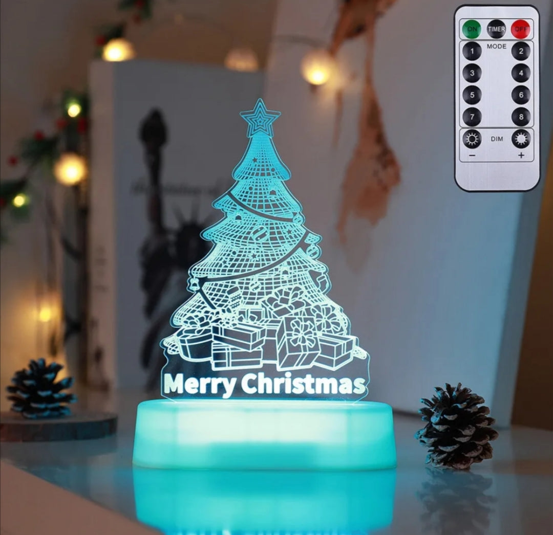 Christmas tree-themed LED night light with remote control on a decorative surface.